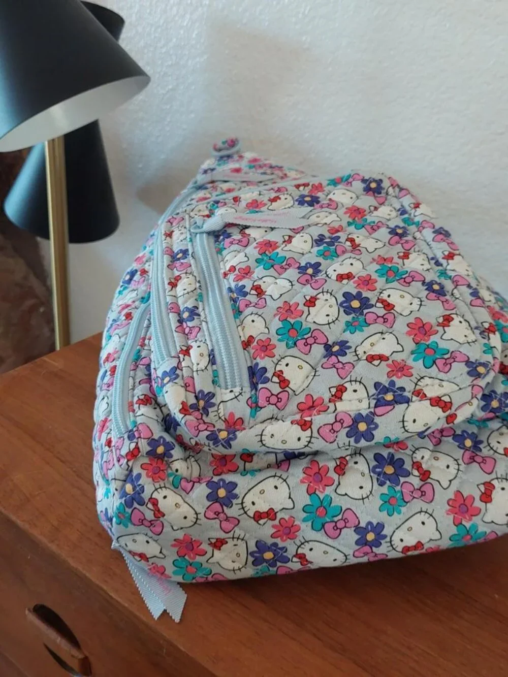 vera bradley Hello Kitty sling bag with repeating Hello Kitty faces and flowers